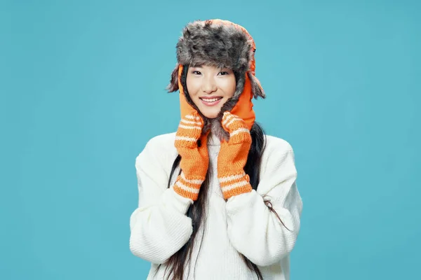 Mulher asiática em chapéu quente e mitenes em fundo azul sorriso inverno modelo — Fotografia de Stock