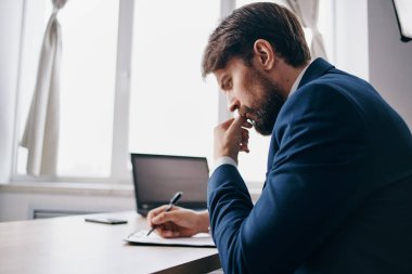 Ofisteki işadamı dizüstü bilgisayarın önünde.