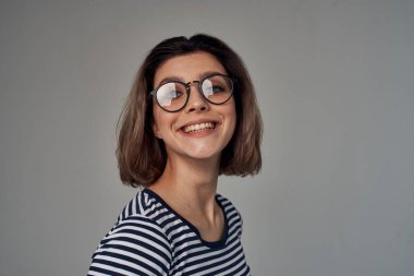 Aydınlık arka planda şık giyinmiş güzel bir kadın. 