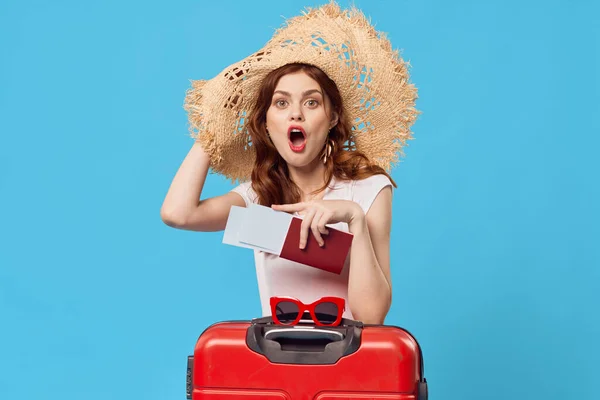 青い背景に赤いスーツケースを着た女性が — ストック写真