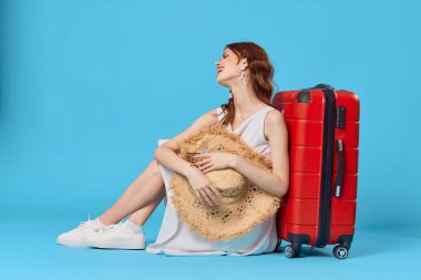 Mavi arka planda kırmızı bavulu olan kadın. Yüksek kalite fotoğraf