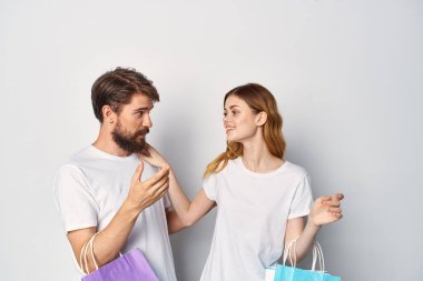 Ellerinde paketler, alışveriş eğlencesi olan genç bir çift.