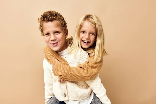 Menino e menina juntos em suéteres divertido casual desgaste bege fundo — Fotografia de Stock