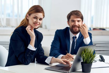 Meslektaşlar dizüstü bilgisayar uzmanları teknolojisinin önünde konuşuyor.