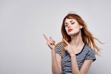 Çizgili tişörtlü hoş bir kadın. Arka planı aydınlık.