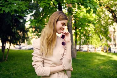 Kadın güneş gözlüğü ve parkta yeşil bir şapka. Yaşam tarzı.