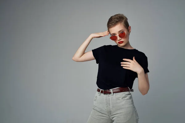 Mooie vrouw in een zwart t-shirt mode donkere achtergrond — Stockfoto