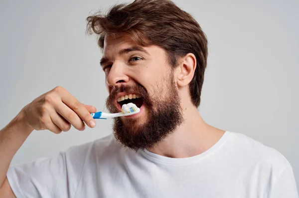 Hombre emocional cepillo de dientes en la higiene de las manos dientes limpios fondo aislado — Foto de Stock