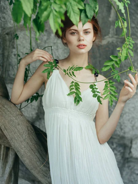 Frau in weißem Kleid in der Nähe einer Steinmauer — Stockfoto