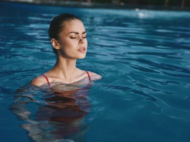 Havuzdaki güzel kadın mayo giyer.