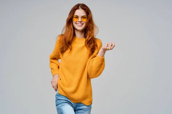 Mujer pelirroja en un suéter amarillo gafas de moda modelo de estudio — Foto de Stock