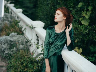 Yeşil elbiseli kadın moda mimarisi ile yürüyor.