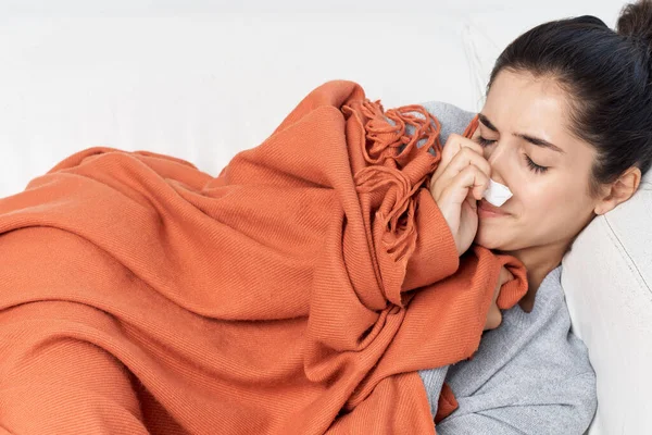 Mujer se acuesta con los ojos cerrados cubiertos con un tratamiento frío manta — Foto de Stock