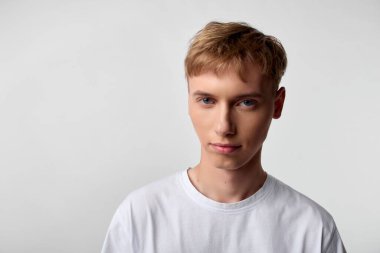 Beyaz tişörtlü, beyaz tişörtlü genç bir adam. Yazı, eko-fotoğraf ya da portföy fotoğrafçılığına uygun bembeyaz bir görünüm ve yumuşak ışıklandırma.