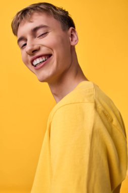 Neşeli ifade ve güneşli kıyafet, seyircilere hitap eden neşeli bir titreşim, sıcak ışıklandırma, modaya uygun bir günlük tarz ve pazarlama, sosyal medya ve yaratıcı kampanyalar için neşeli bir atmosferi vurguluyor