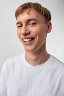 Temiz beyaz tişörtlü rahat, dost canlısı adam, modern reklamcılık, markalaşma ve sosyal medya kampanyaları için uygun sıcaklık ve güven yayıyor.