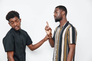 Siyah tenli Afro-Amerikalı erkekler tartışıyorlar, bir işaret parmağı, günlük kıyafetler, duygusal etkileşim, stüdyoda beyaz arka planda izole edilmiş..