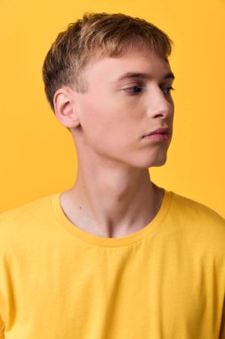 Sarı gömlekli sıradan bir erkek figürü hafif ışıklandırma, temiz kompozisyon, modern estetik, moda, gençlik ya da yaşam tarzı kampanyaları için ideal.