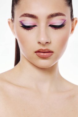Zarif kadın modeller mor kanatlı göz farı ve pürüzsüz çıplak dudaklardan esinlenerek kusursuz deri dokusunu vurgularlar. Güzellik yaratıcılığı ve moda ilhamı için stüdyo çekimi.