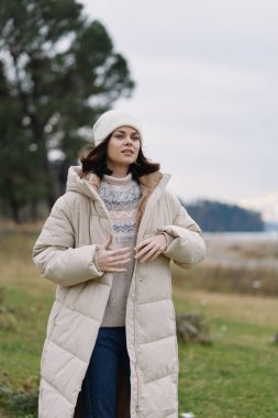 Kışlık palto, açık hava portresi, soğuk hava, kadın, bere, sakin bir yürüyüş sırasında yakalanan rahat kıyafet, hışırdayan ağaçlar ve geniş gökyüzü..