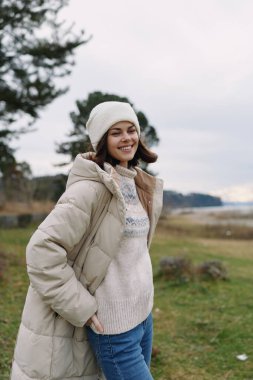 Yüzünde kabarık bir palto ve örgü bulunan, yaşam tarzı, doğa ve mevsimsel konforu yakalayan, güler yüzlü, kar manzaralı bir kadının günlük portresi..