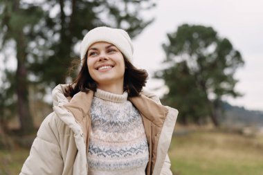 Açık havada gülümseyen sonbahar ceketi beresi doğa manzarasının tadını çıkaran açık hava havasında sakin bir portre.