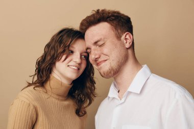 Sevecen genç bir çift, gözleri kapalı ve gülücükler saçıyor. Bej balıkçı yakalı kadın beyaz gömlekli adama yaslanıyor. Aşk kavramı, samimiyet, güven ve duygusal bağ..