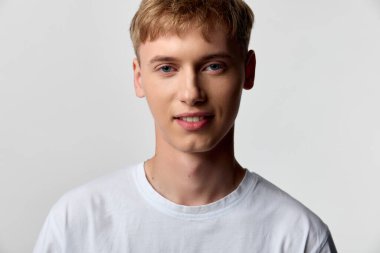 Parlak bir stüdyoda tişörtlü, rahat bir poz ve temiz bir geçmiş, yaşam tarzı, reklamcılık, marka kampanyaları ve ekomünikasyon görselleri için uygun..