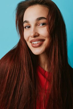 Düz kahverengi saçlı, yumuşak gülüşlü, kırmızı bluzlu genç bir kadın. Açık tenli yakın plan portresi, doğal güzellik ve rahat bir ruh hali..