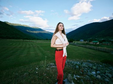 Çimen tarlaları ve yuvarlanan tepeler, berrak gökyüzü, sakin kırsal bölge, sıradan kıyafet, macera anlayışı, doğa manzarası ve uçsuz bucaksız ufuk.