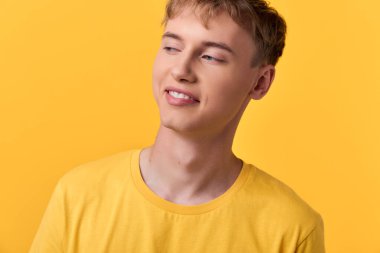 Sarı tişörtlü genç adam, rahat duruşu ve olumlu havası olan, markalaşma ve reklam için ideal, çağdaş görünüş ve modern medya için günlük giyimi olan