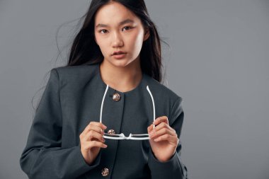 Uzun saçlı, gri gözlüklü, kendine güveni tam bir kadın kameraya bakıyor..