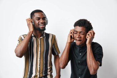 Siyah tenli, kulaklık takan, müziği hisseden, mutlulukla dans eden, gündelik tarz ve arkadaşlığı beyaz arka planlı stüdyoda yakalayan genç siyahi adamlar..