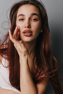 Genç kadın portresi dalgalı saçlar ve ince makyajlı yüz dokunuşu moda, güzellik, manken çekimi ve evde sakin bir ifadeyle kişisel bakım..