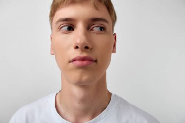 Yan bakışlı sıradan bir erkek, basit bir arkaplan, minimum ışıklandırma, markalaşma için modern ruh hali, kurumsal teminat veya stok kütüphanesinde reklamcılığı ve dijital medyayı destekleyen yaratıcı kampanyalar.