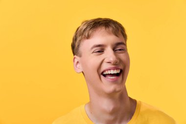 Işıl ışıl sırıtan neşeli erkek denek canlı sarı arkaplan, sıcaklığını, yaklaşılabilirliğini ve pozitif titreşimleri reklam, refah ve takım işbirliği bağlamları için uygun.