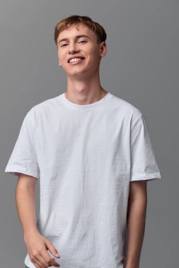 Mutlu bir ifade ve minimalist bir geçmişe sahip basit bir gardırop. Açık bir moda, rahat bir poz ve günlük yaşam tarzı ve stüdyo fotoğrafçılığı cazibesi.