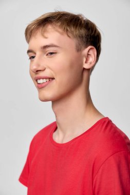 Neşeli ifadeli, kırmızı bluzlu, sıradan görünümlü, stüdyo ışıklandırması, yakın çekim yaklaşımı, modern tarzı, enerjik havası ve pazarlama için günlük moda cazibesi olan bir erkek.