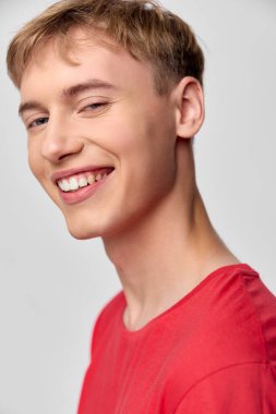 Geniş bir gülümsemeyle neşeli gençler, canlı ışıklandırma ve iyimser titreşim medya kampanyalarında yaşam tarzı, mutluluk ve olumlu markalaşma için idealdir.