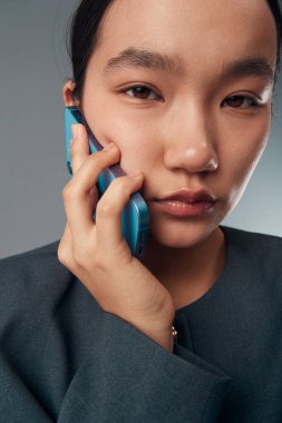 Düz derili bir kadın arama ve bağlantı için akıllı telefon kullanır, dijital iletişim ve ağ için yumuşak ışıkta ayrıntılı özelliklere sahip yüz ve eli kapatır.