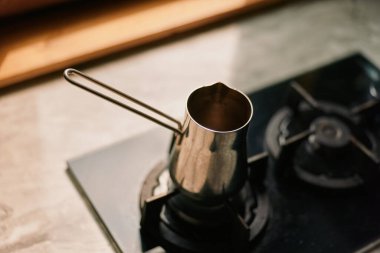 Mutfak sahnesinde üst düzey kahve demliği ve metal çaydanlık, demleme işlemi, alet edevat, aroma ve rahat ruh haline odaklanma..