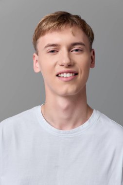 Parlak gülüşlü, kısa saçlı ve sade tişörtlü neşeli erkek figürü, markalaşmaya, yaşam tarzı içeriğine, reklamcılığa ve ürün vitrinlerine arkadaşça ve kendinden emin bir tavır sergiliyor.