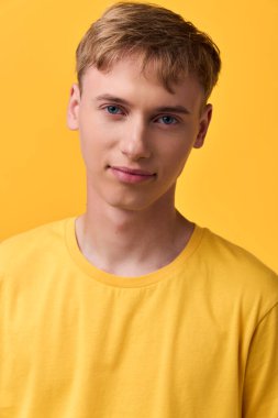 Sarı arka plana karşı sarı giysili erkek model, sıcak hava ve kendine güvenen ortam, stüdyo düzeni, moda, yaşam tarzı, pazarlama ve reklam kullanımı için yakın görünüm