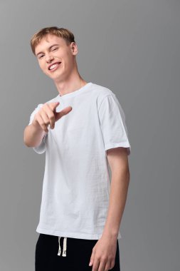 Seyirciye yönelik dostane bir jestle sıradan bir gençlik, basit bir kıyafet içinde rahat bir duruş, reklamcılığa, uçağa binmeye veya bir stüdyoda promosyon mesajlarına yaklaşılabilirliği ve güveni vurguluyor.