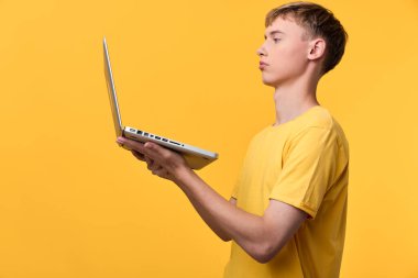 Teknolojinin, öğrenmenin, verimliliğin, uzaktan çalışmanın ve modern bir kurulumda hızlı dijital iletişimin altını çizen, parlak sarı arka planı inceleyen bir adamla, teknolojik açıdan bilgili bir ruh hali.