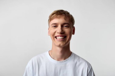 Günlük kıyafetli bir gencin neşeli vesikalığı iyimserliği, kendine güveni, modern yaşam tarzı, yaklaşılabilir marka cazibesi, kurumsal refah, sosyal medya kampanyaları ve