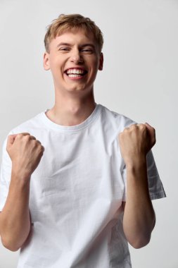 Neşeli ifade ve kutlama pozu güven ve motivasyonu gösterir, beyaz gömlek, iyimser ruh hali, pozitif enerji, dinamik ve canlı titreşim markalaşmadan