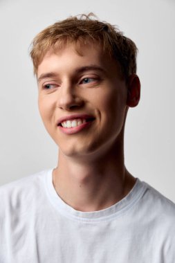 Açık renk saçlı, düz tişörtlü, samimi pozlu, pozitif enerjili ve günlük özgünlük, sosyal medya için çok yönlü görüntü, dış ticaret ya da temiz editoryal kullanımla arkadaş canlısı, neşeli genç bir adam.