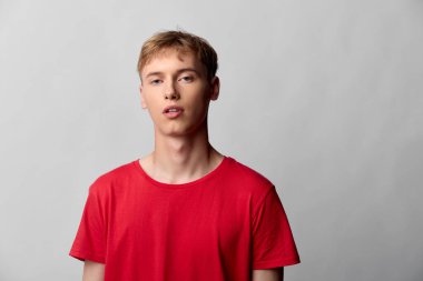 Günlük bir stüdyoda kırmızı gömlek giyen bir adam, nötr bir iç mekanda editör, reklamcılık veya ticari projeler için uygun minimum temiz estetiğe sahip ifade ve moda sergiliyor.