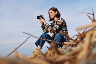 Kareli gömlekli ve kotlu günlük kıyafetler, deniz kıyısında seyahat ve doğa fotoğrafçılığı, manzara ve yansımaları ustaca hazırlanmış kompozisyon ve sabırla belgelemek..